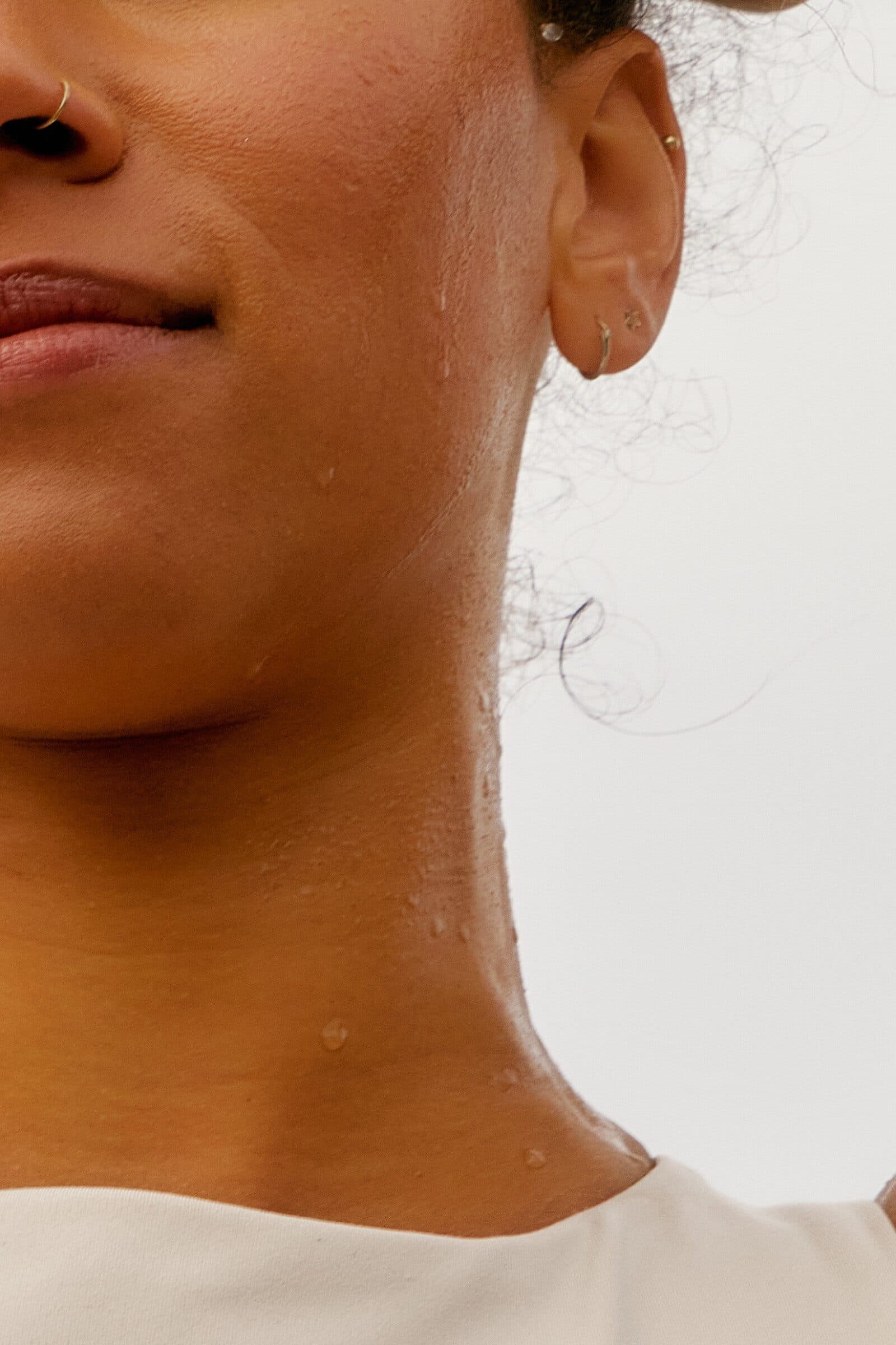 Close-up of a woman’s chin and neck with water droplets on her skin